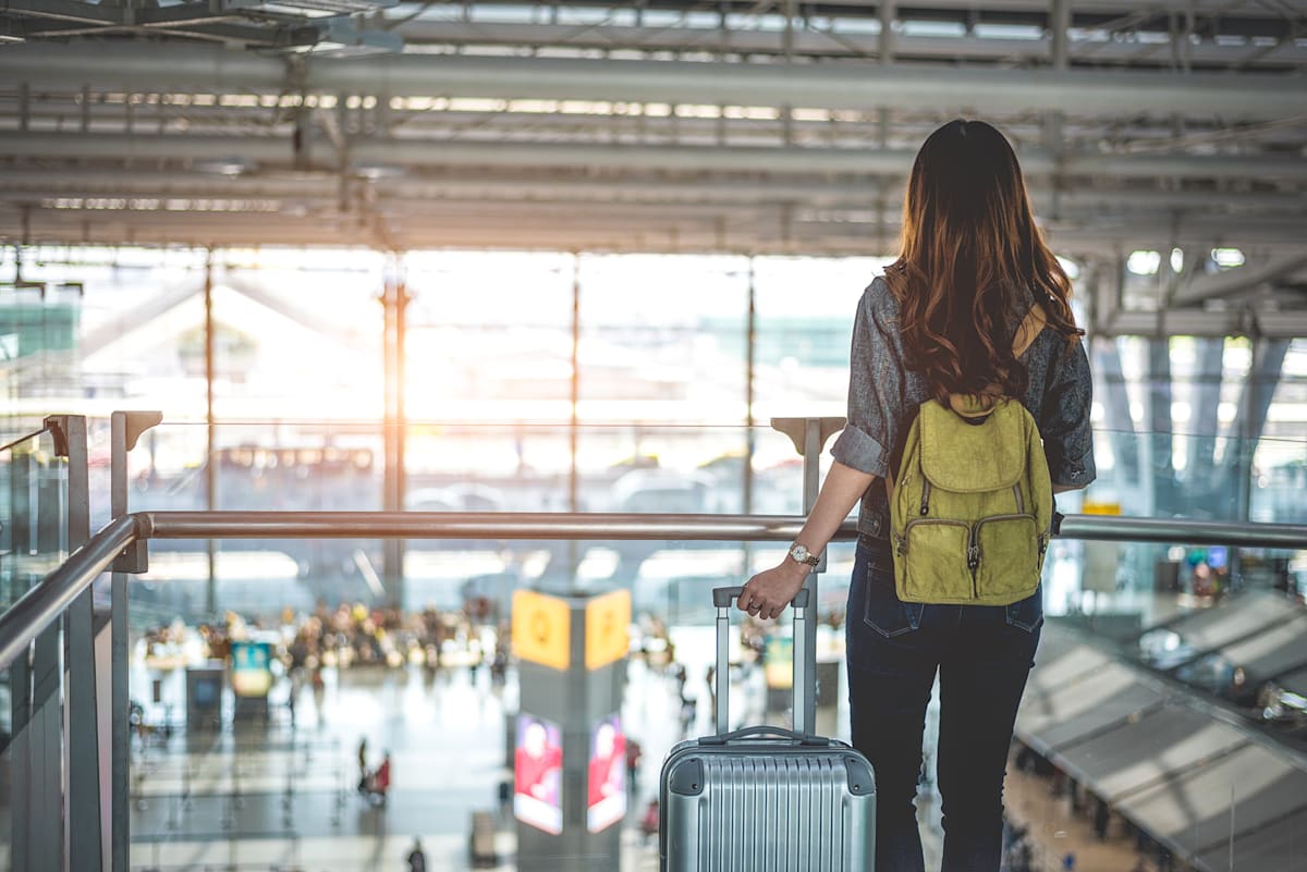 Image of female student in airport with luggage