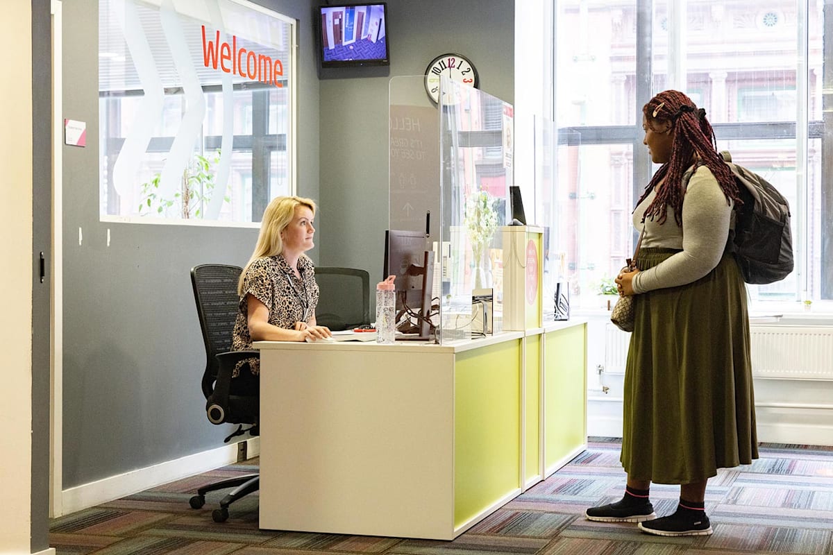 A student being greeted at the welcome desk at INTO Manchester