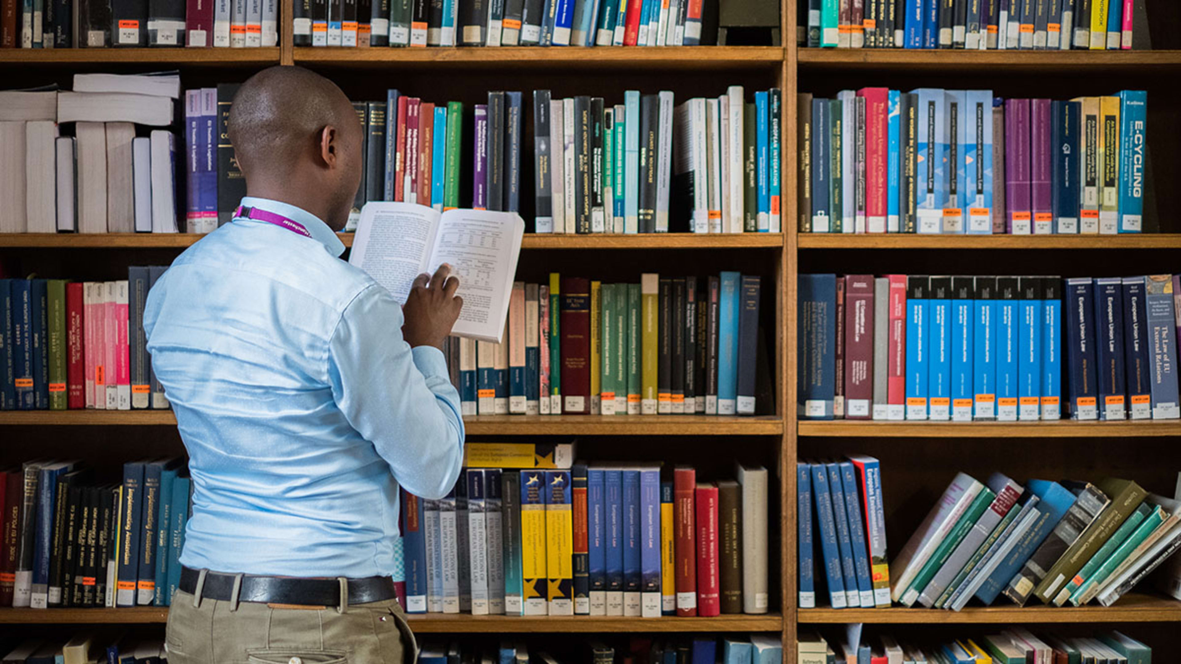 Man reading a book standing in the Library