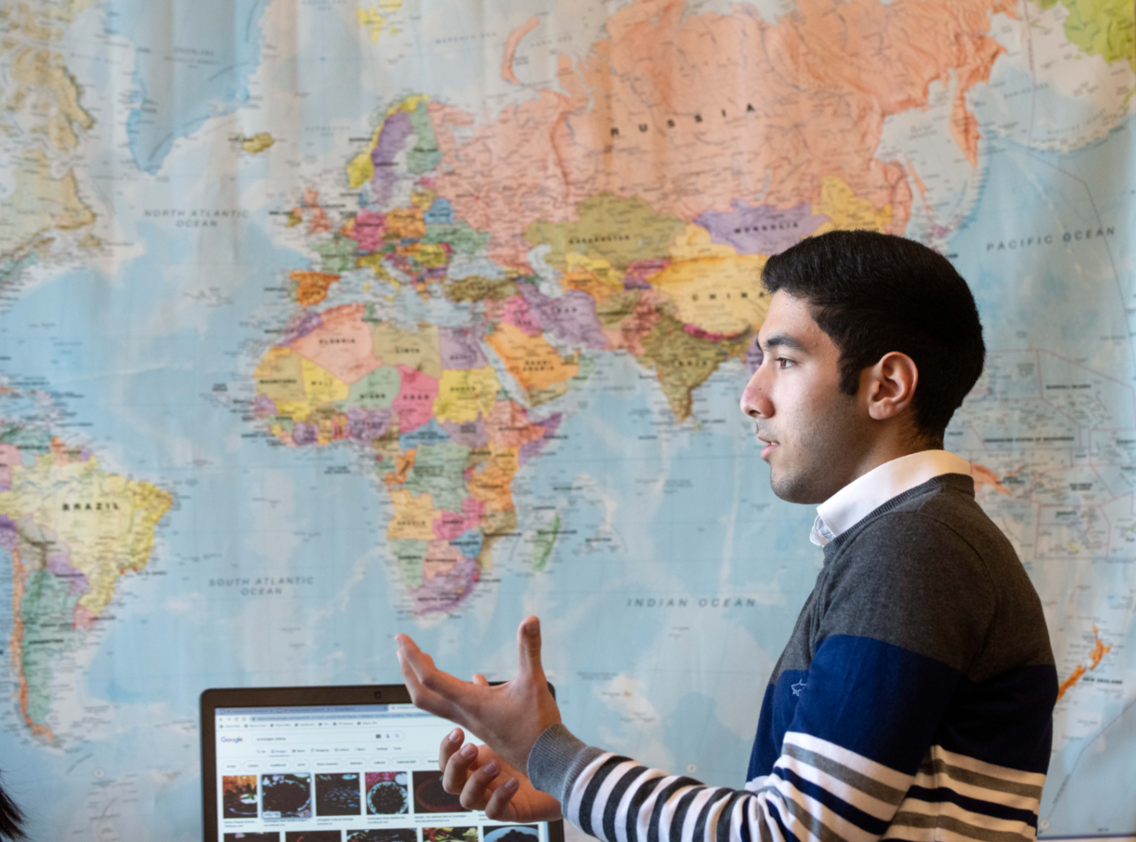 Student in front of world map