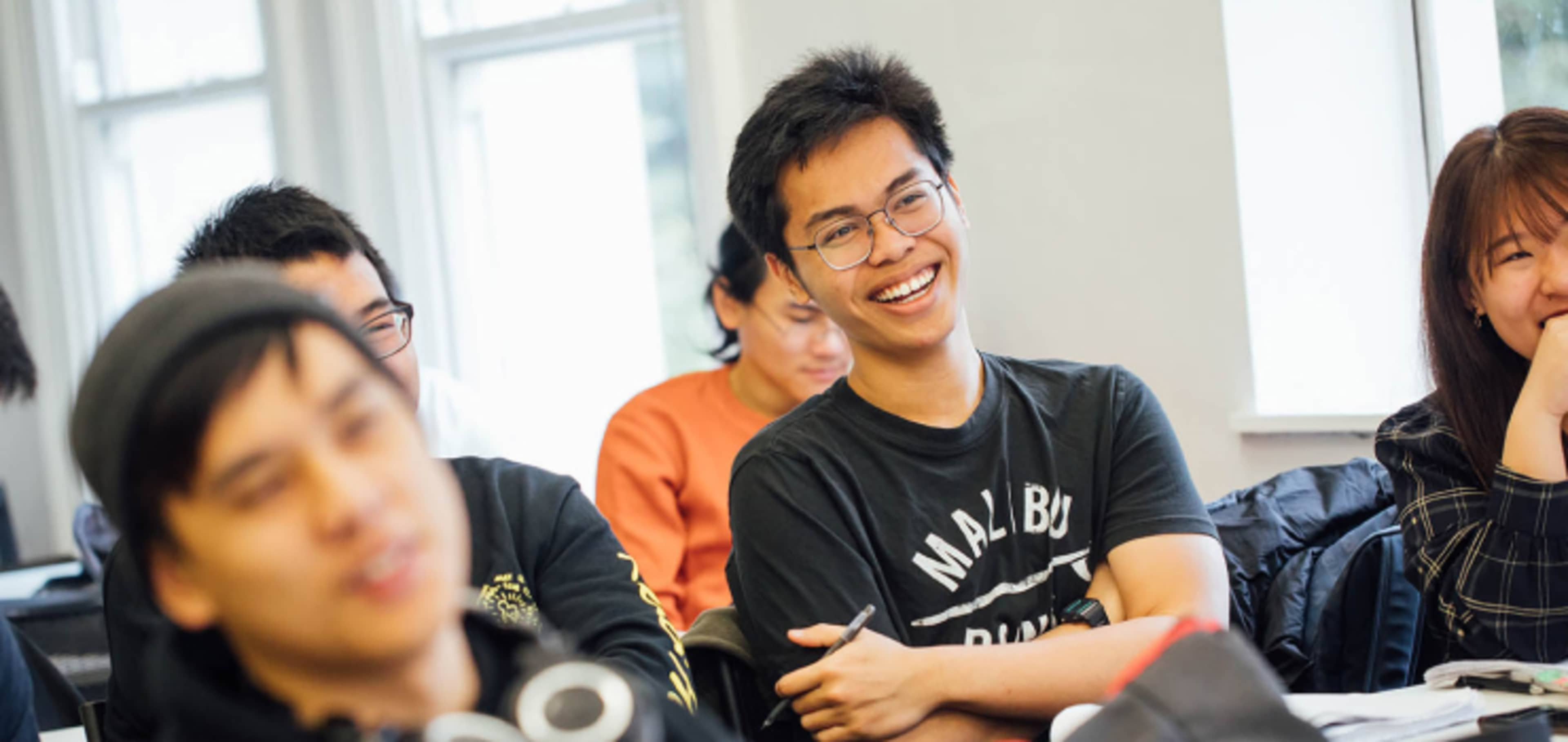 Smiling, happy students in class room at Queen's University Belfast