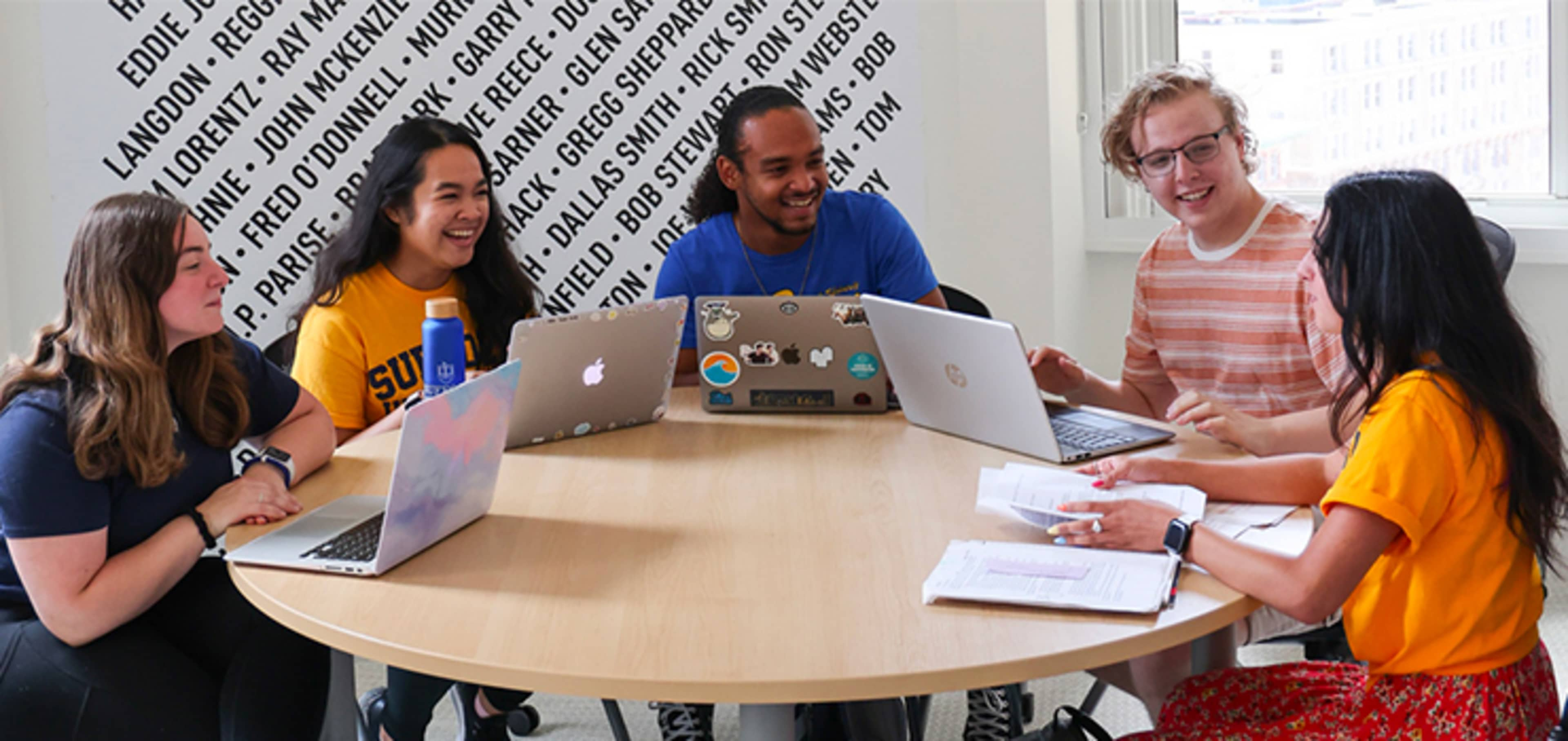 Suffolk students sitting at a table on campus 