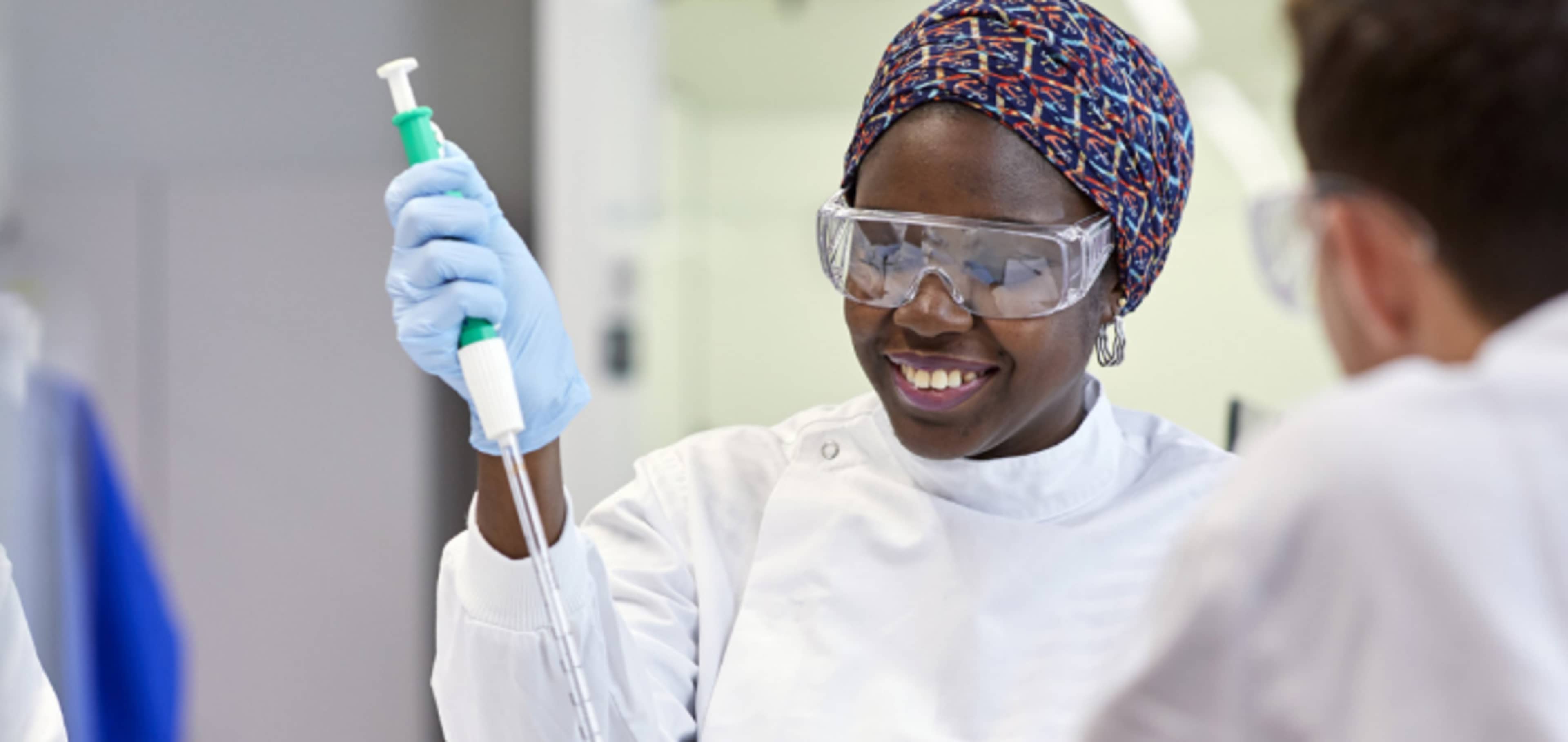 Postgraduate science student in laboratory undertaking practical experiment