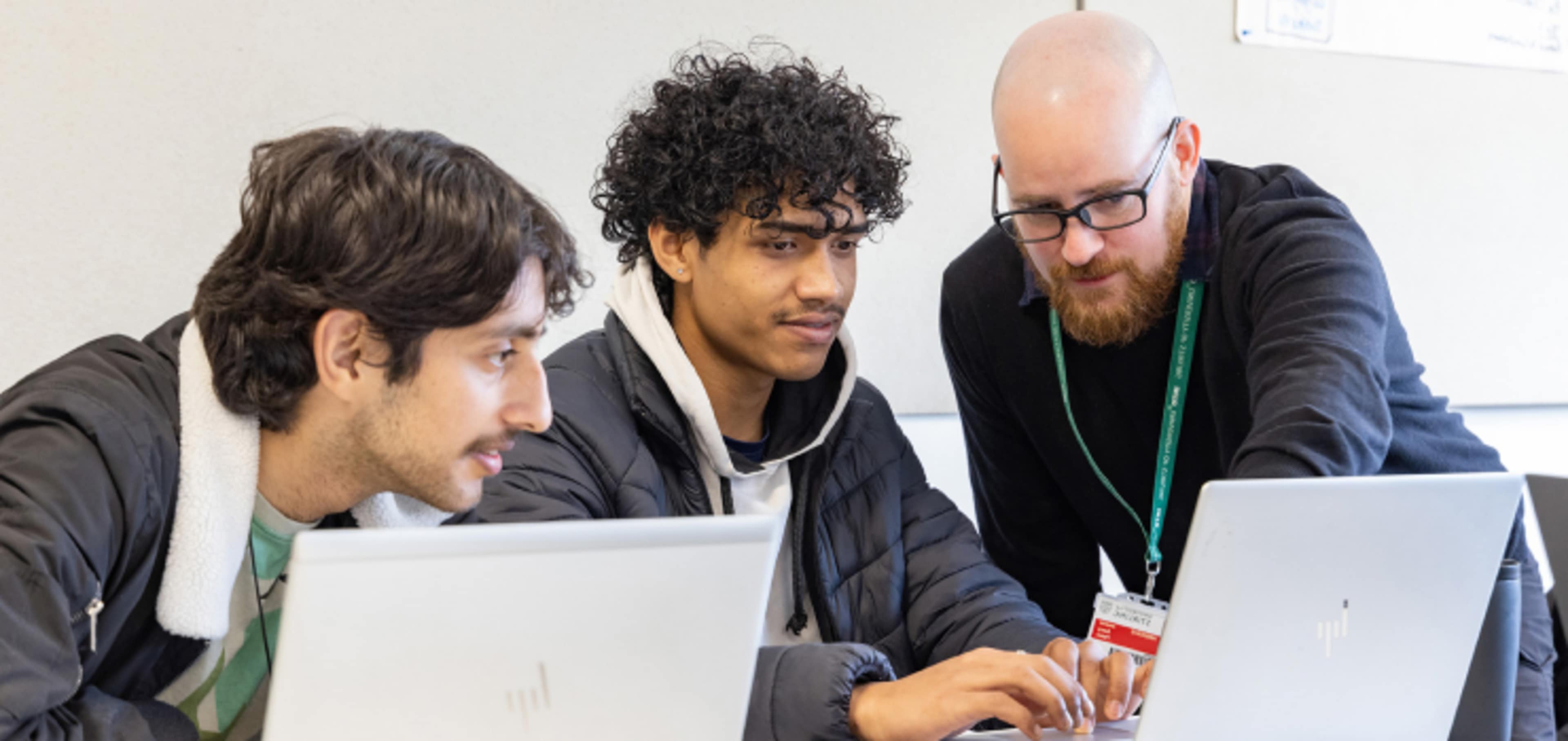 Two English language students talking with university tutor 