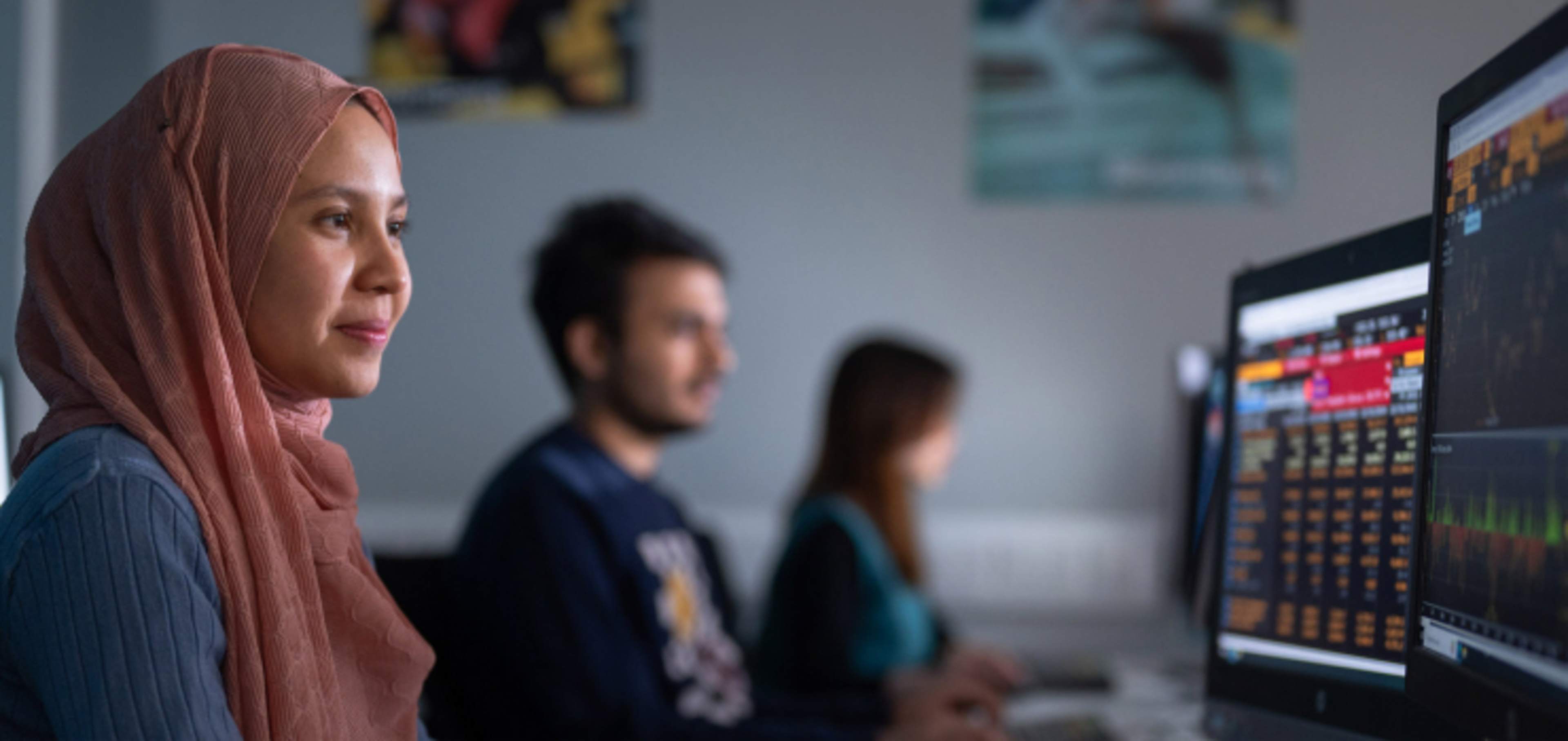 Undergraduate student wearing headscarf working at computer