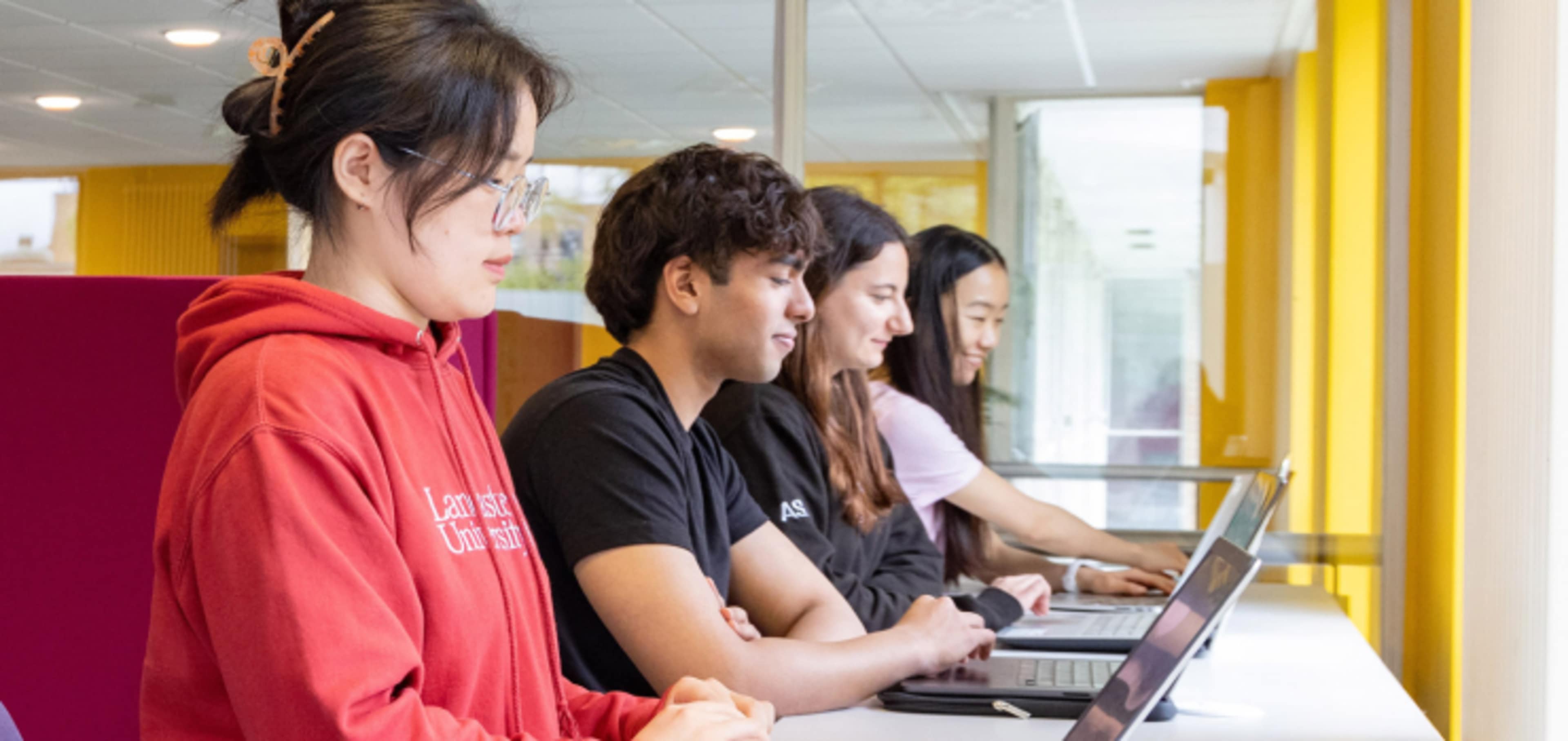 Group of English language students in a line working at computers