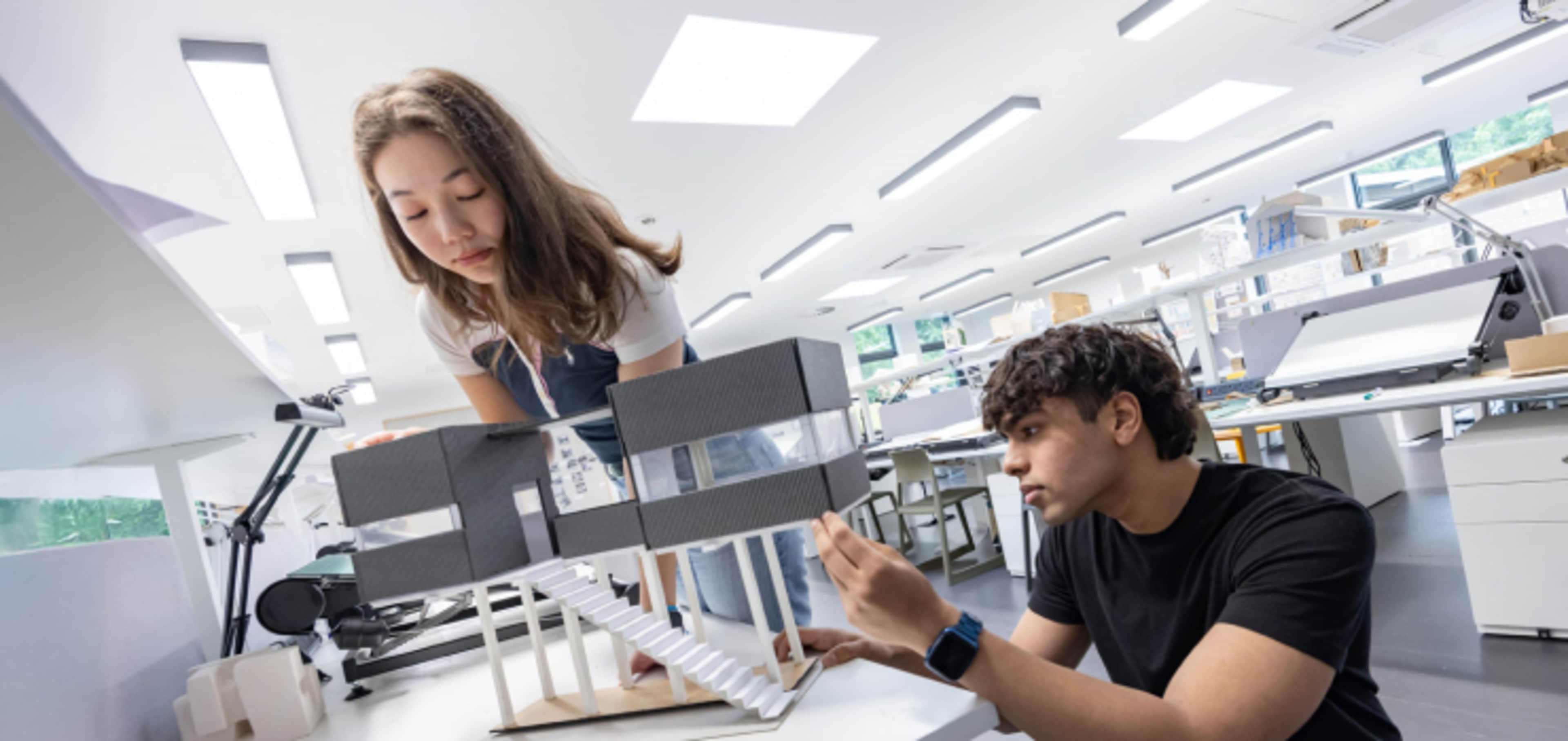 Two postgraduate courses students working on scale model