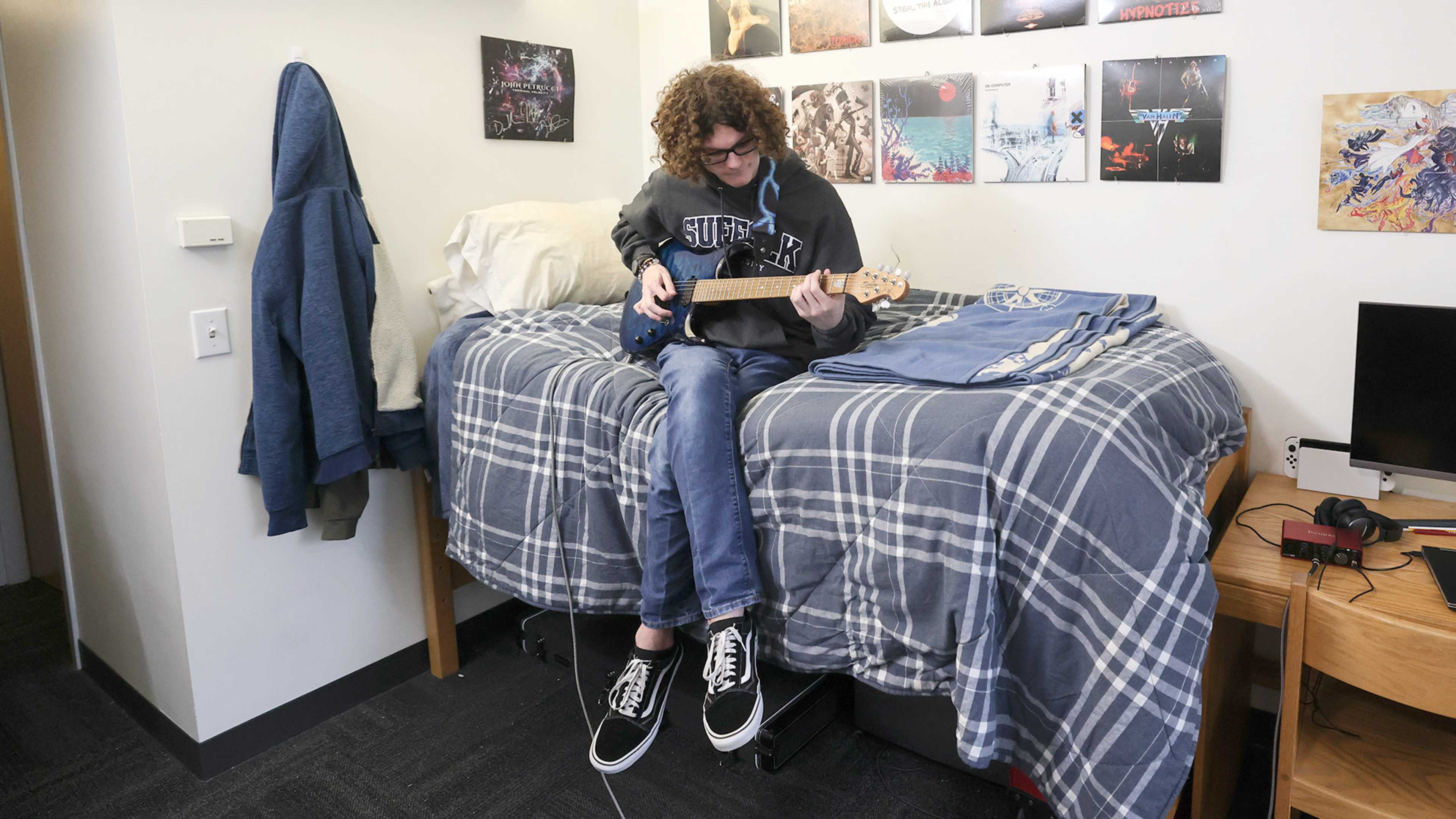 Suffolk student playing guitar in dorm