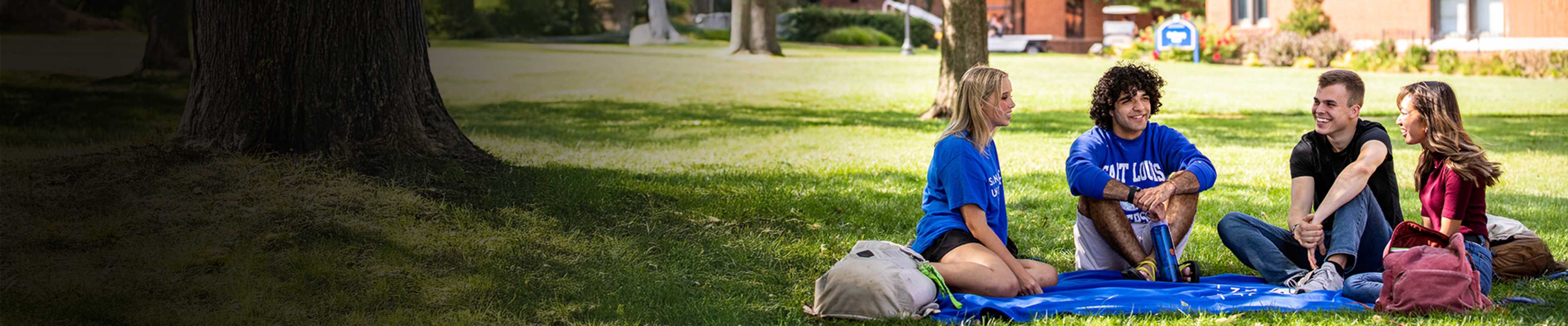 SLU student sitting on lawn