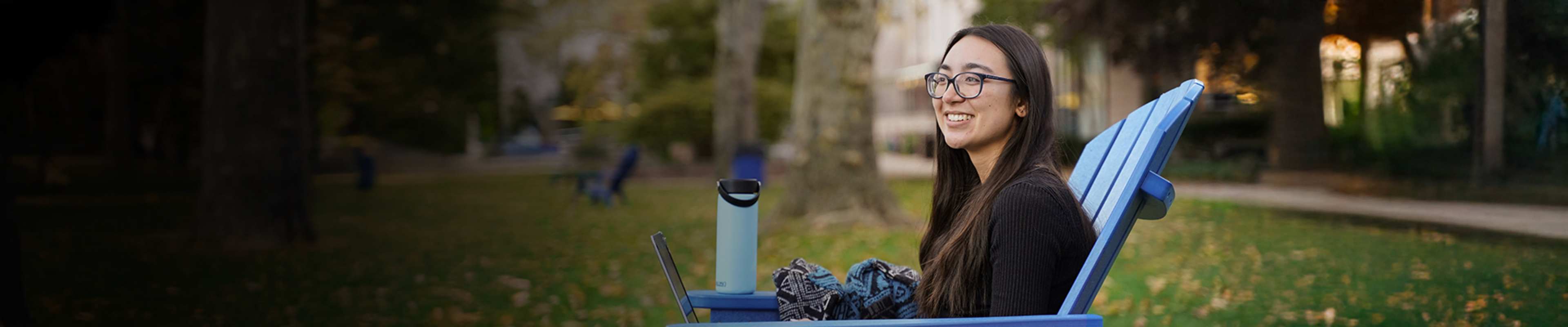 Hofstra student sitting in chair on lawn