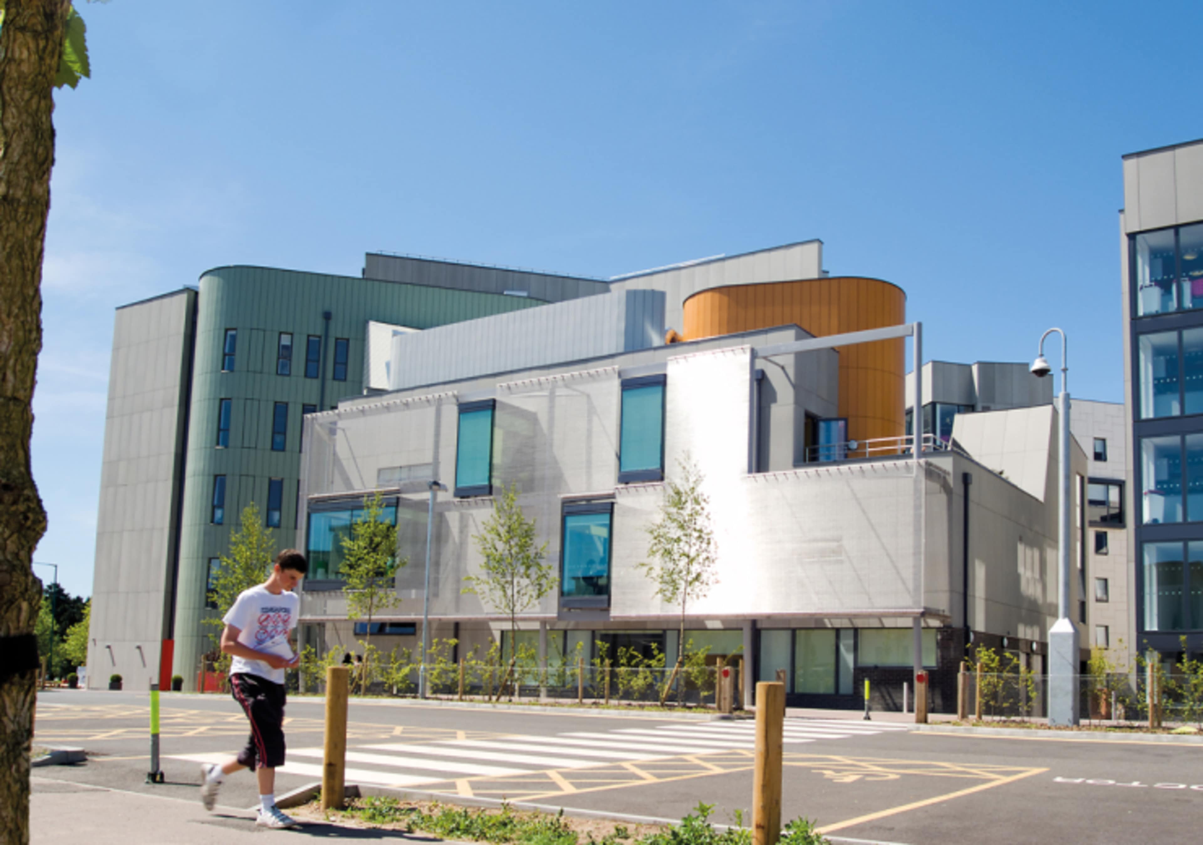 Student walking with UEA International Study Centre backdrop