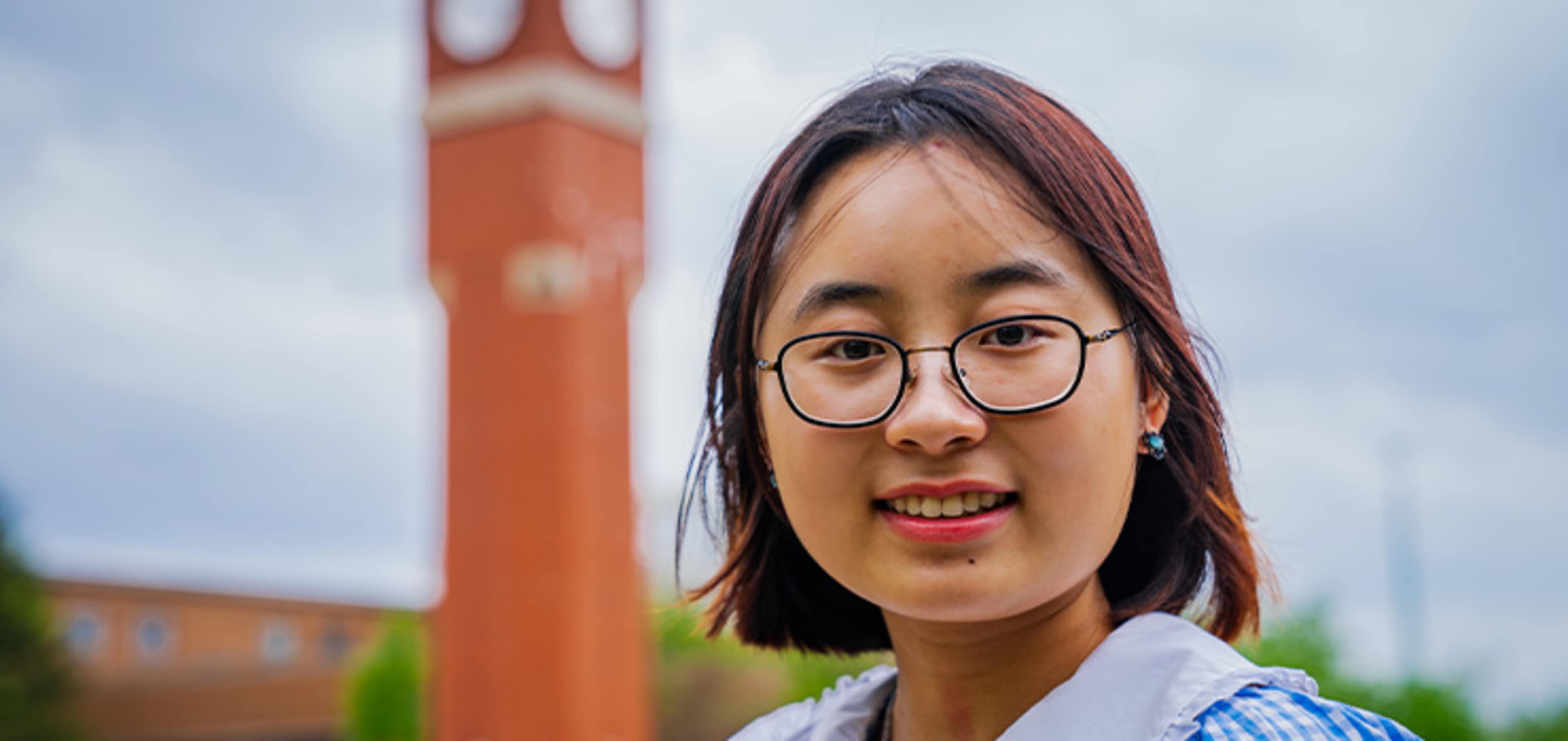 Student with a clock tower behind