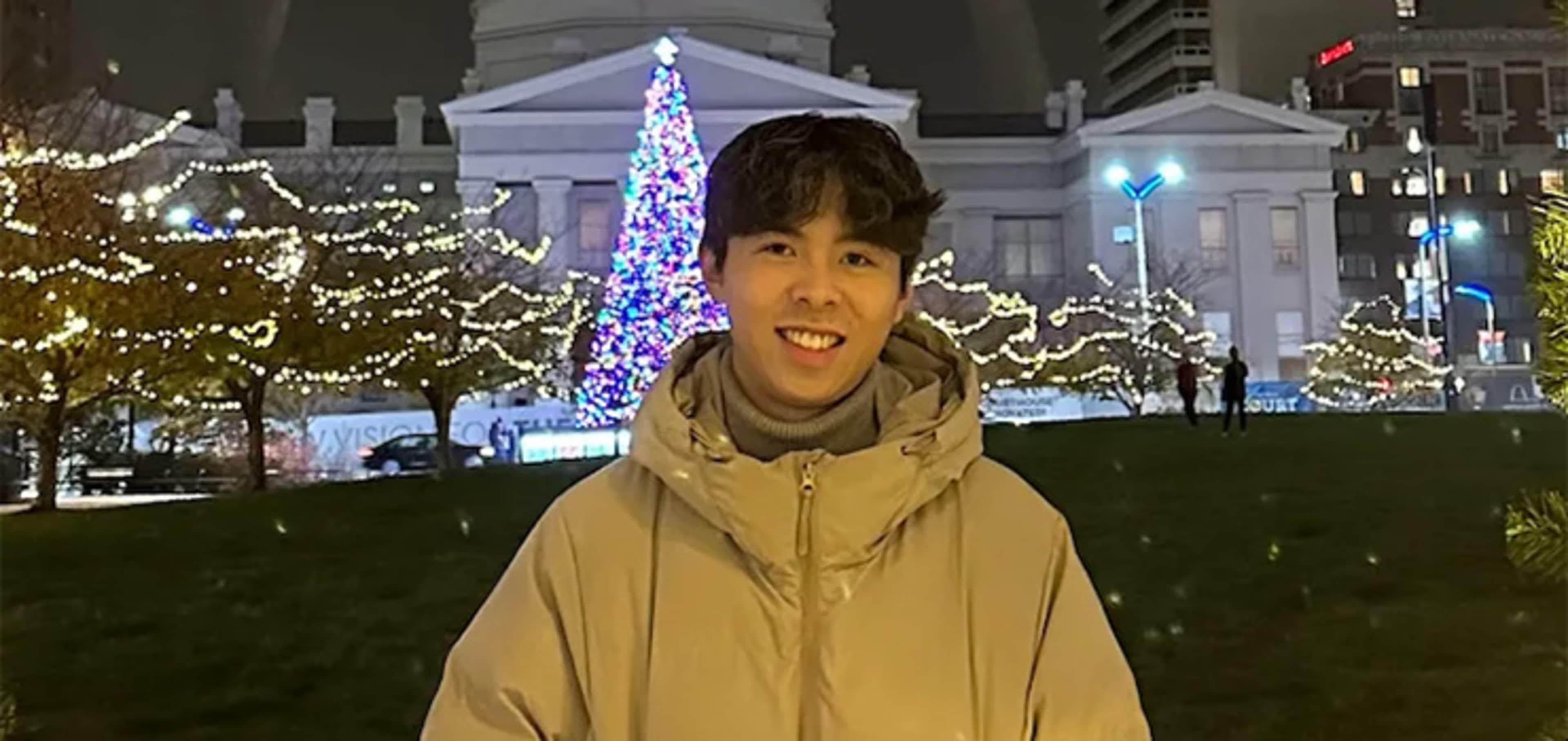 Student in front of a building celebrating Christmas