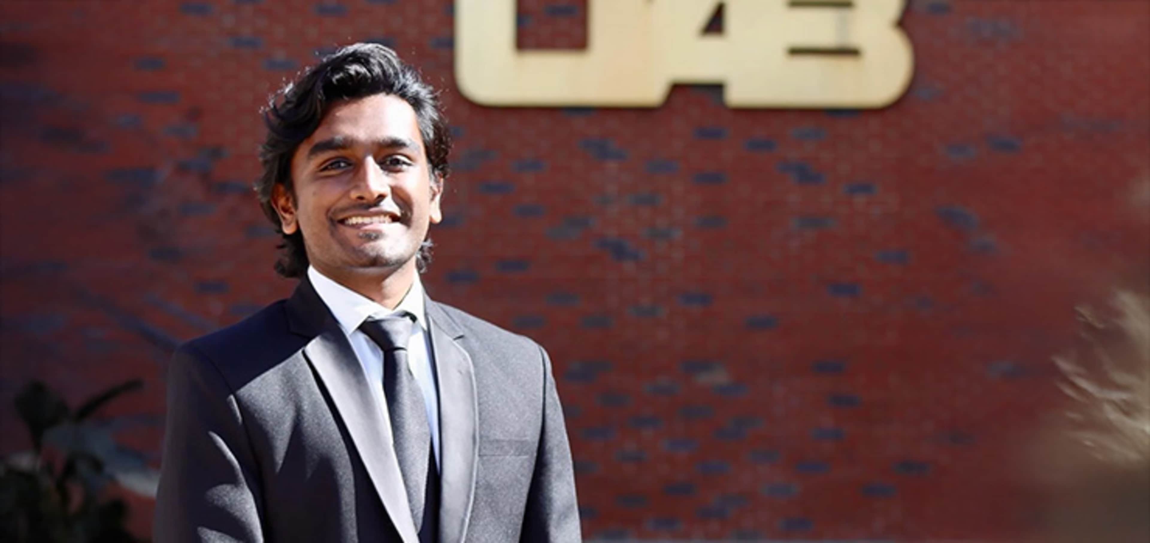 Student smiling in front of a building