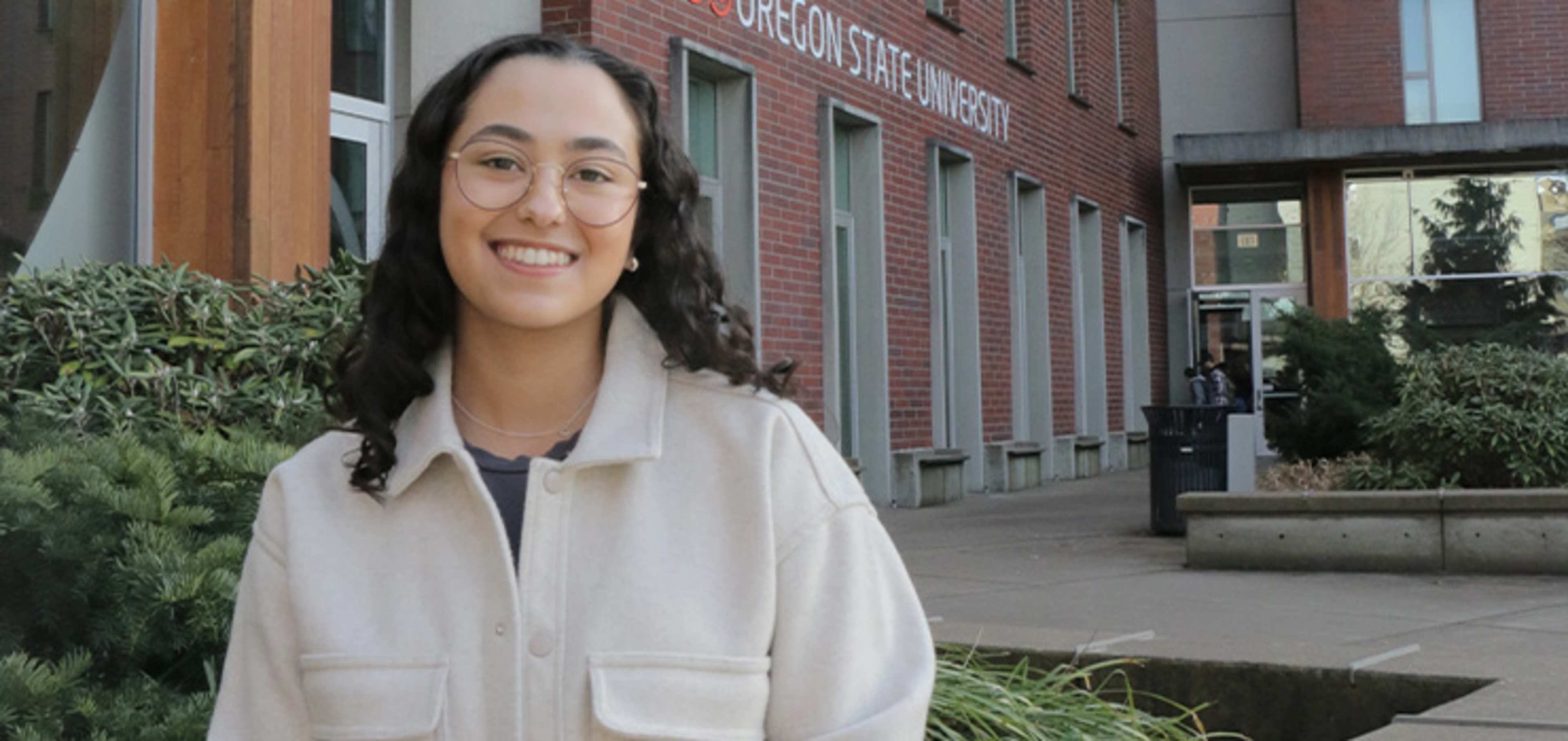 Smiling student in front of a building