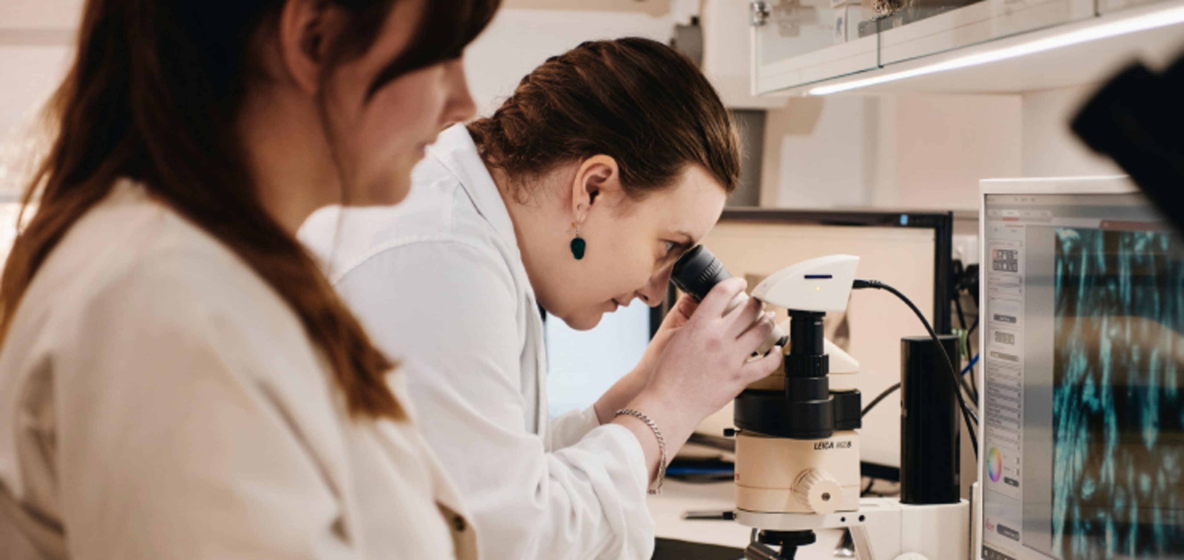 Student looking through microscope 