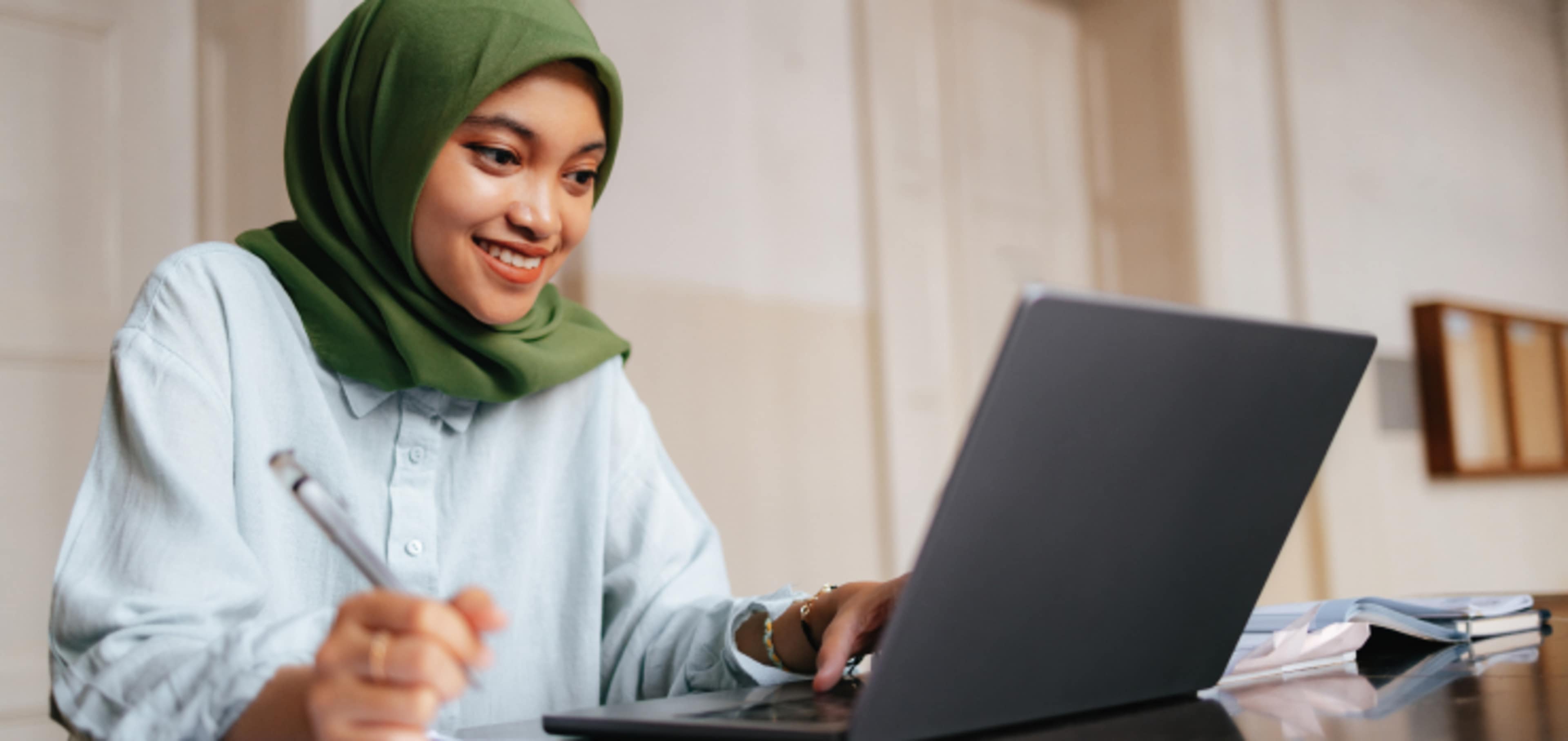Student looking at his notes and laptop