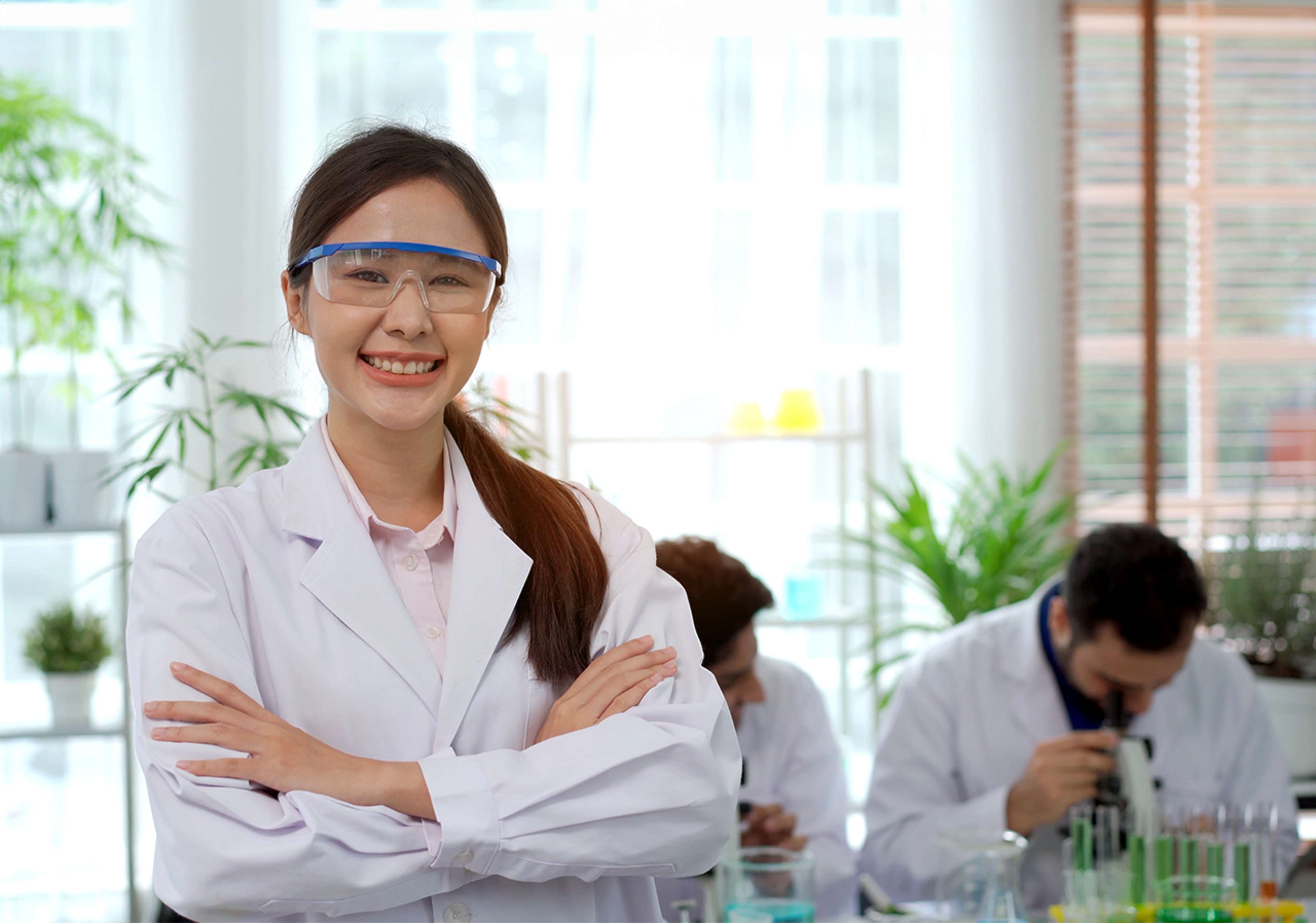 Student in a lab smiling at the camera