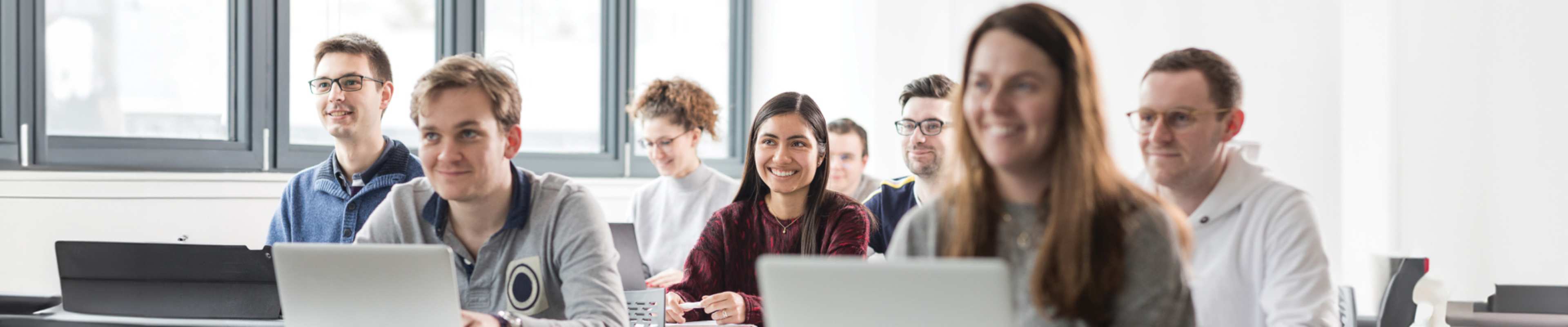 Camera focused on an international student among peers in a classroom environment