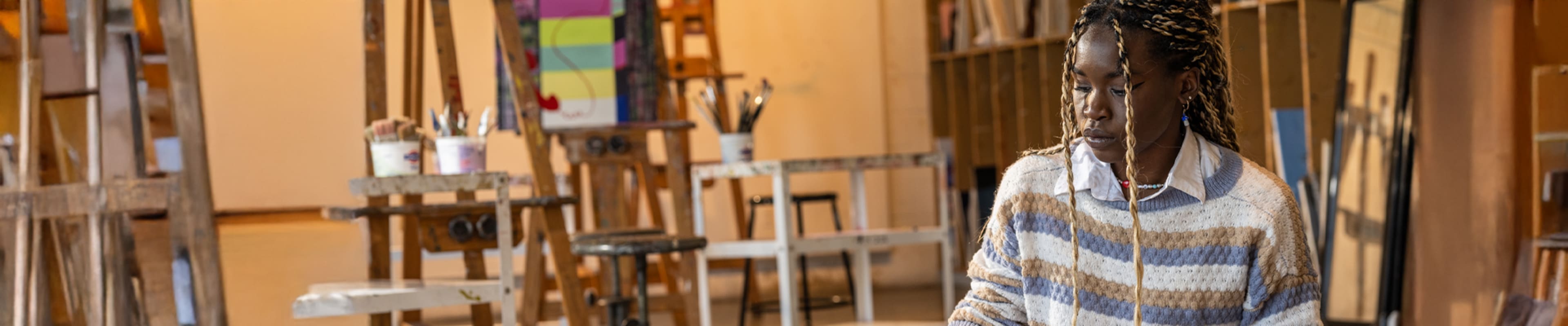 Student looking into her desk and creating a piece of art