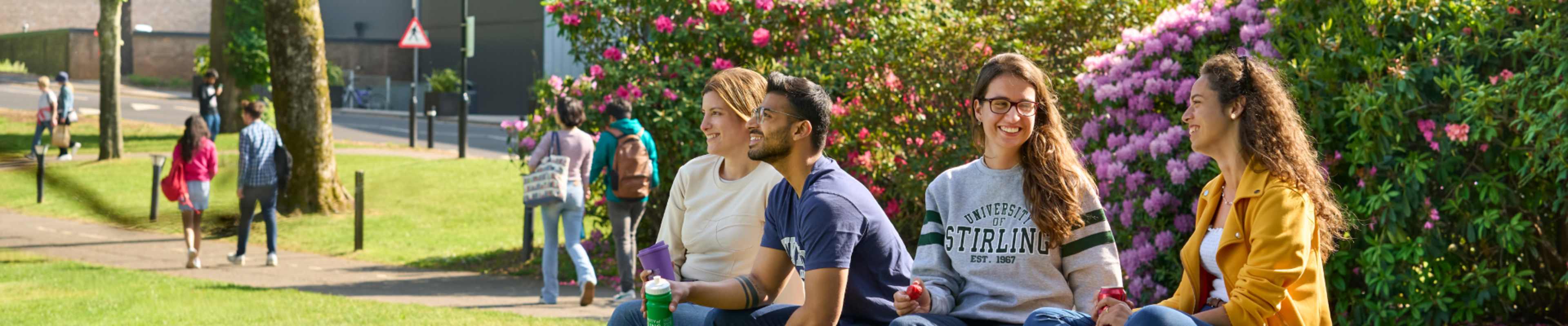 Students hanging out on the grass at the University of Stirling