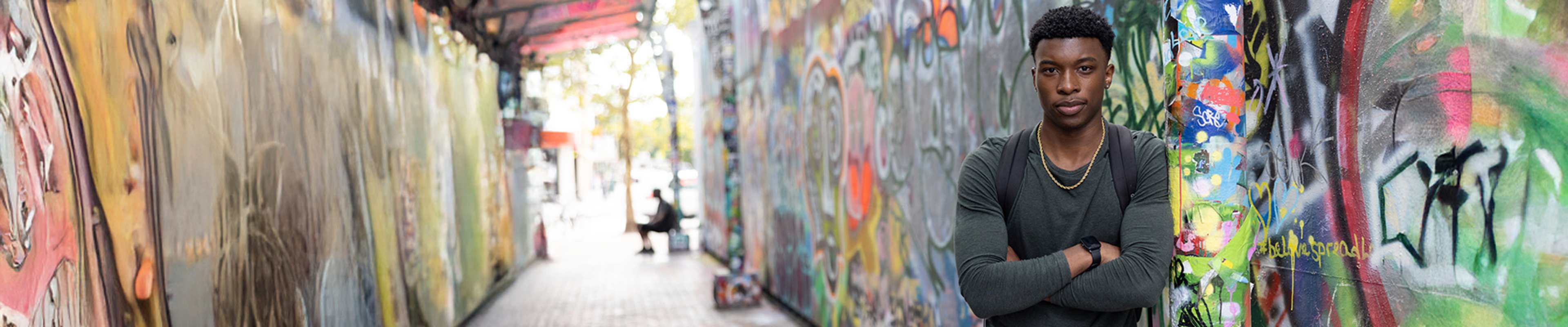Student next to a wall facing the camera
