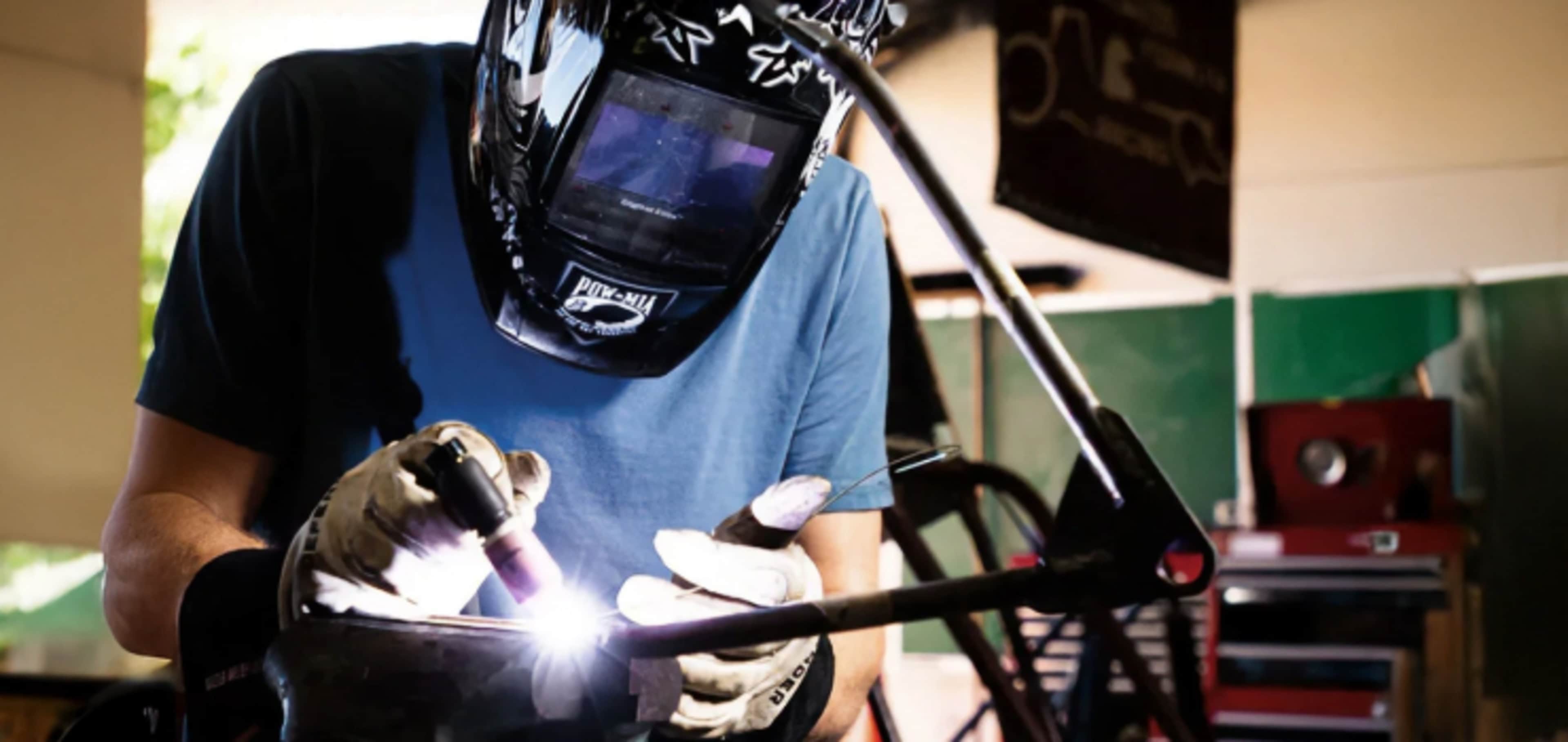 Engineering student welding metal