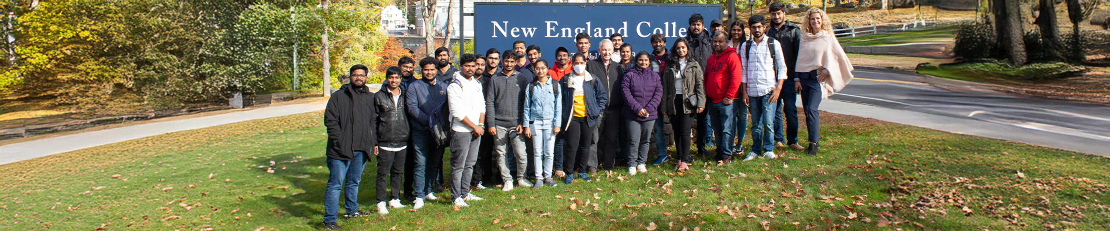 Group of students standing in front of a Univesrity Banner