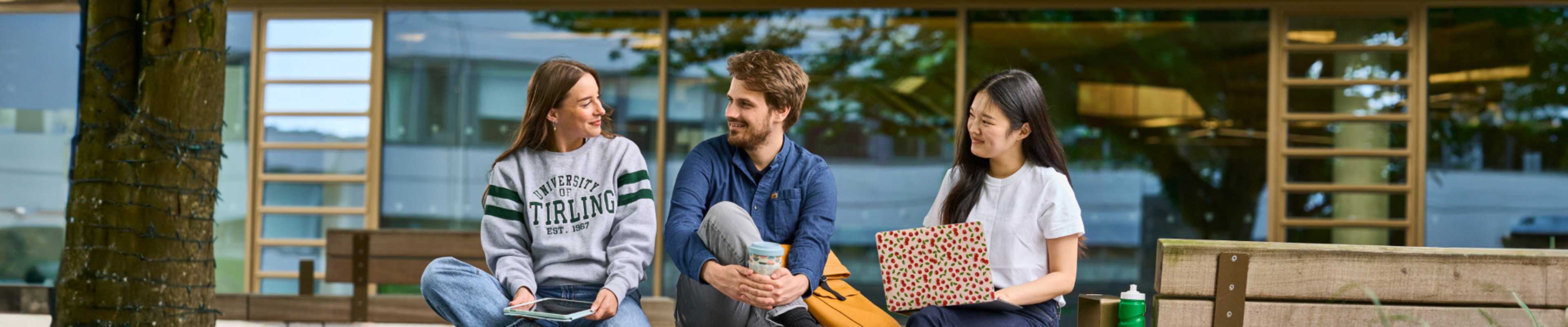Three international students having a conversation inside Stirling campus
