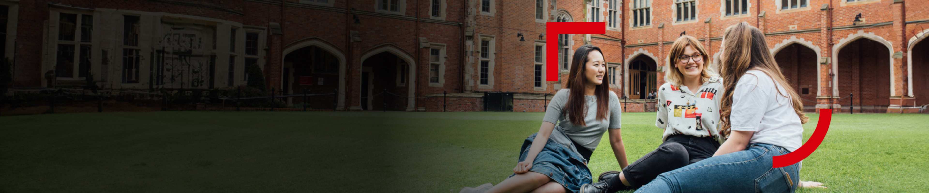 Three international students talking to each other on the university campus grounds