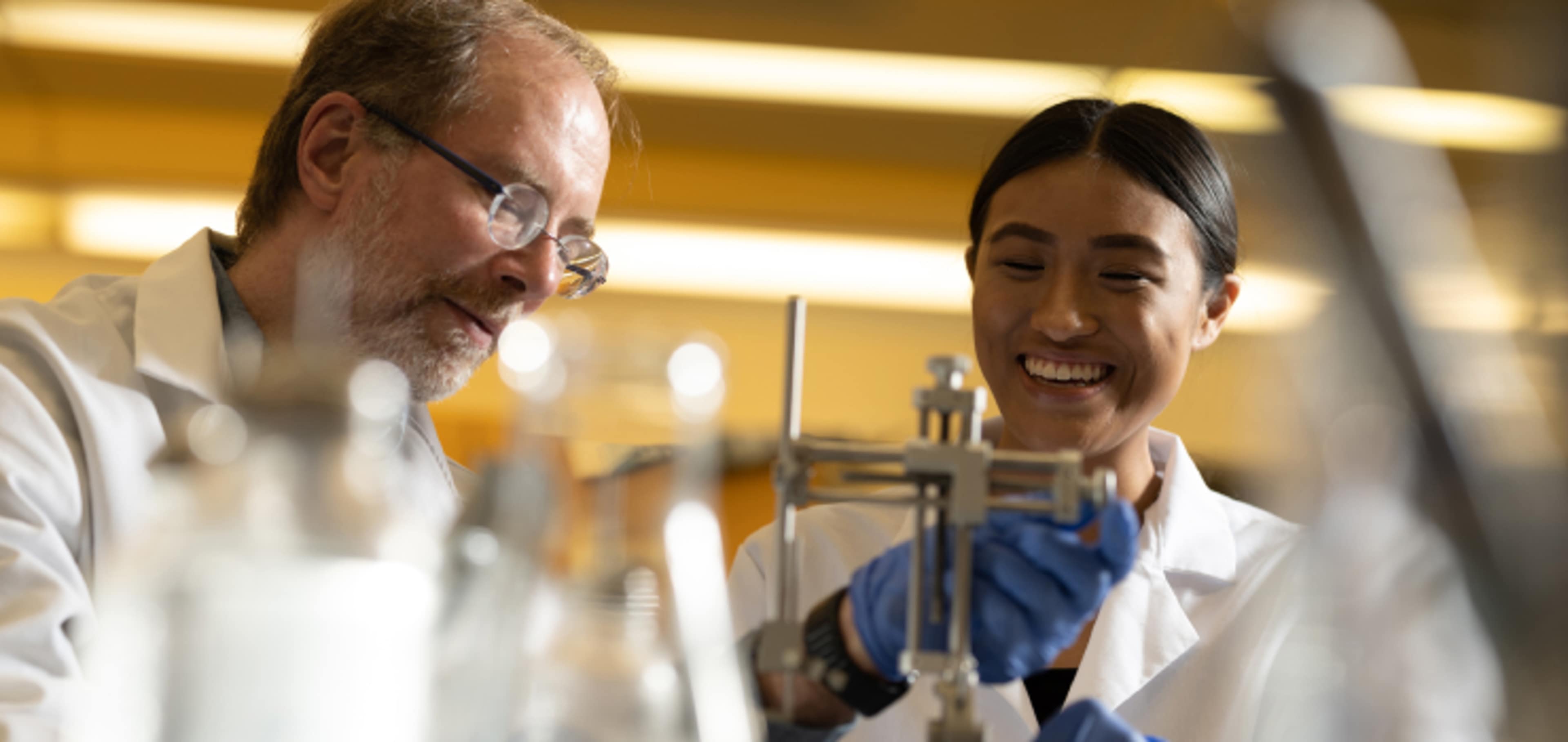 Smiling student with tutor in lab