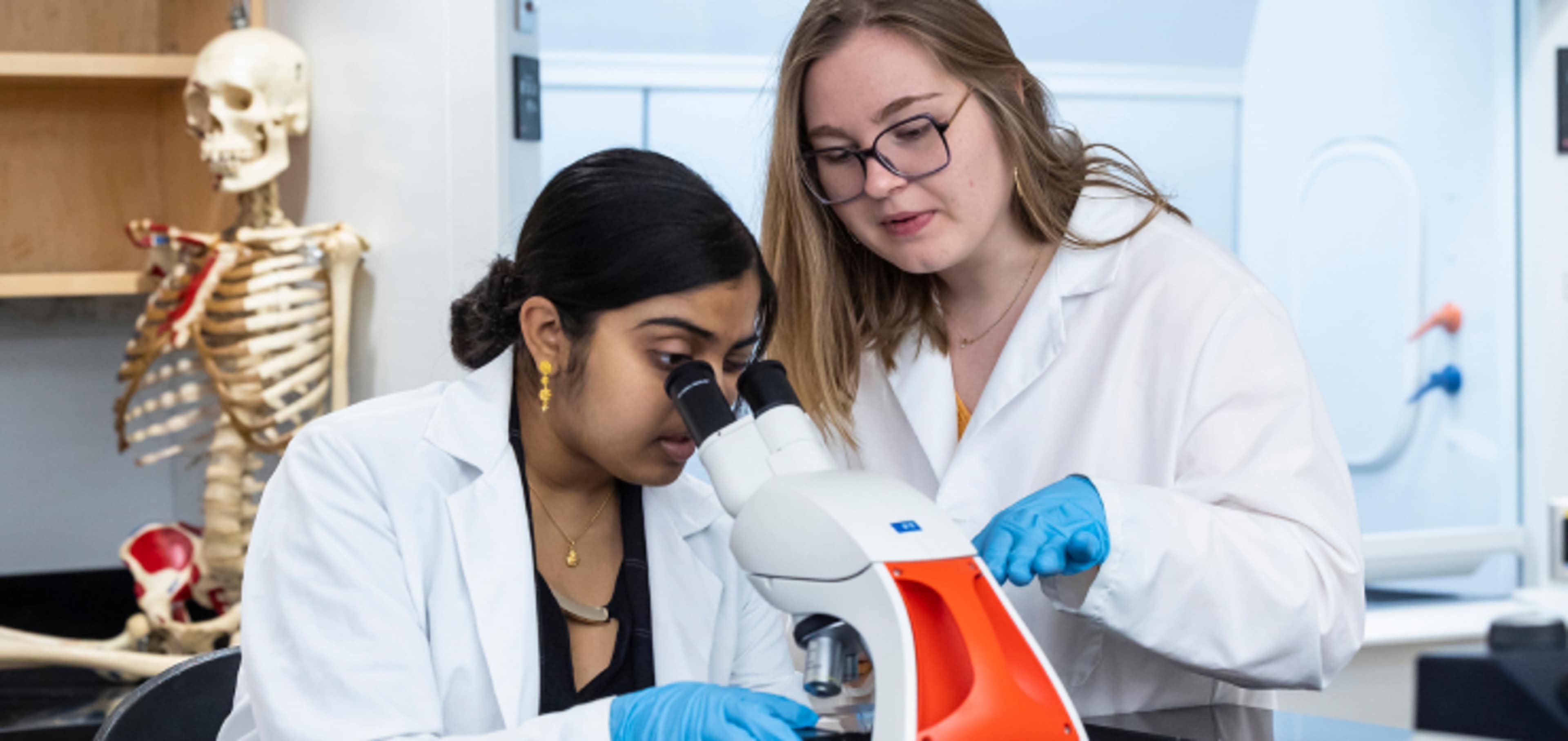 Two students looking through microscope 