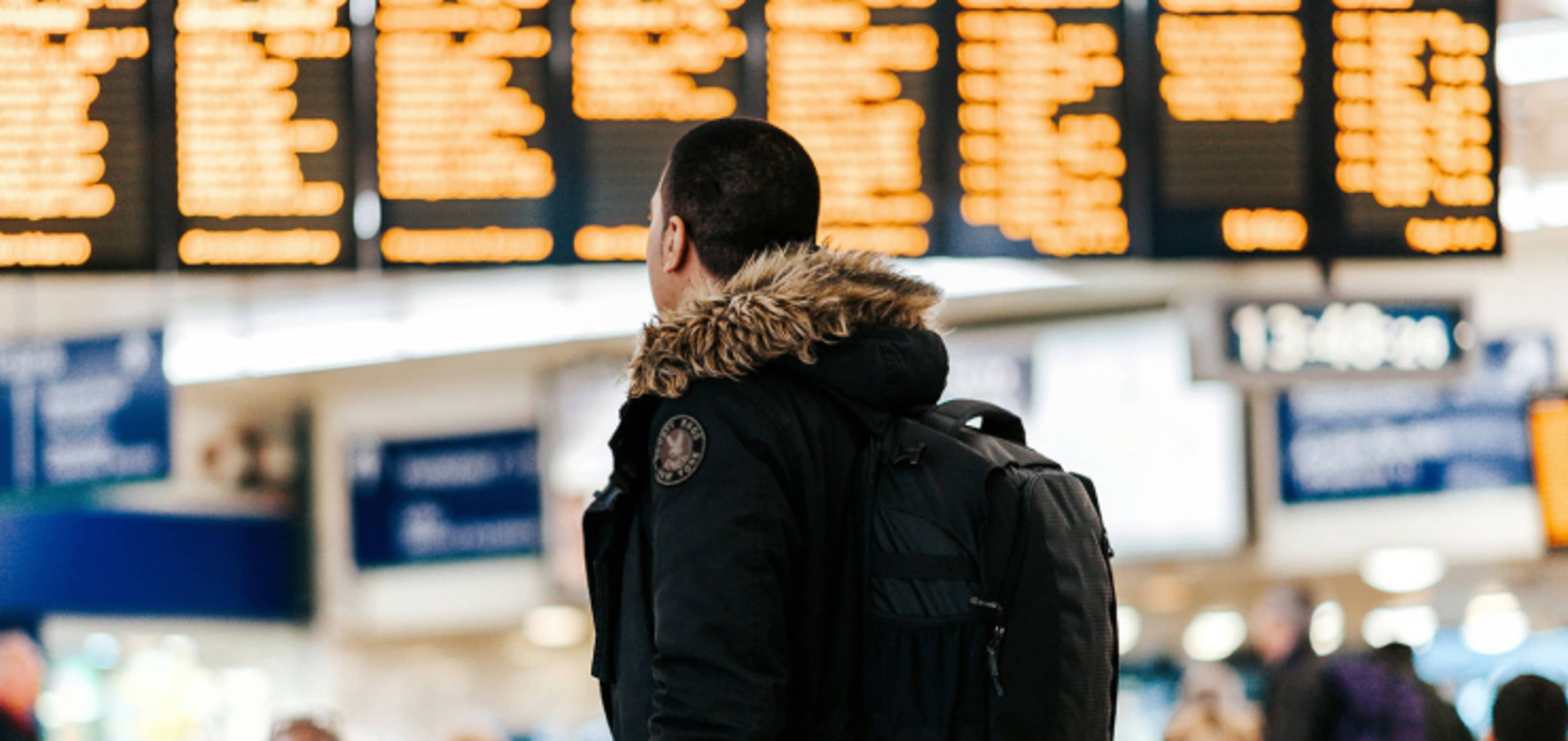 Student at airport checking flight progress